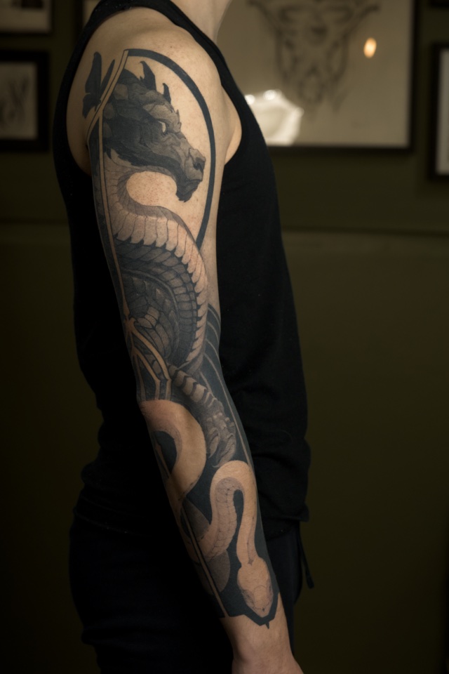 Tatouage d’un dragon sur un bras par Bryan Ly